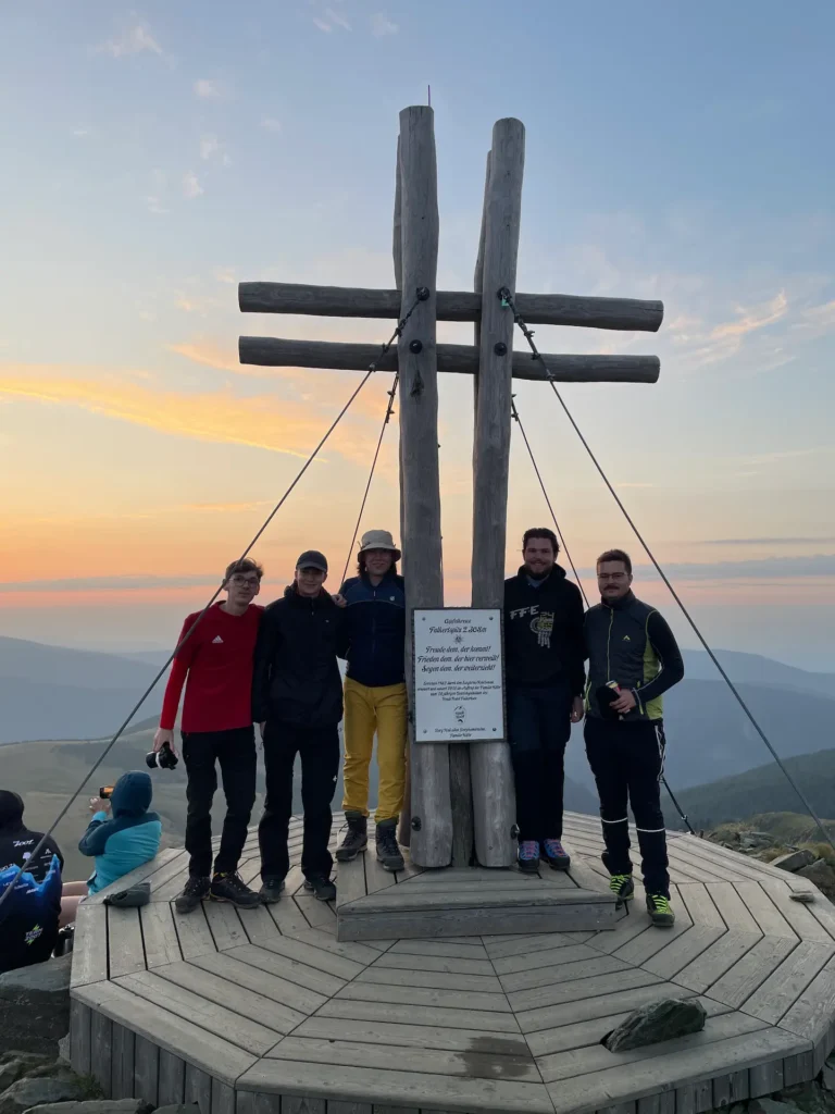 vereinsmitglieder vor dem gipfelkreuz am falkert
